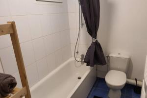 a bathroom with a toilet and a bathtub with a black curtain at Appartement contemporain rénové à neuf avec cuisine équipé - Val de reuil in Val de Reuil +11 photos