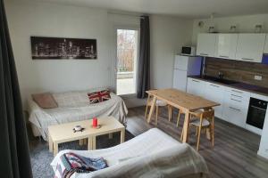 a living room with a kitchen and a table at Appartement contemporain rénové à neuf avec cuisine équipé - Val de reuil in Val de Reuil