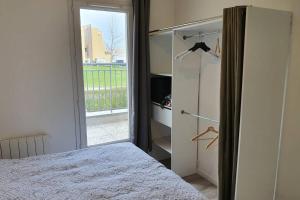 a bedroom with a bed and a sliding glass door at Appartement contemporain rénové à neuf avec cuisine équipé - Val de reuil in Val de Reuil