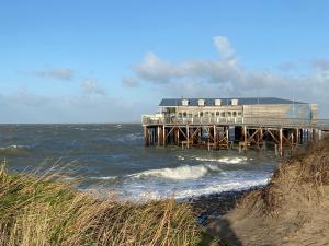 een gebouw op een pier in de oceaan bij Ferienhaus Nordseeliebe in Scharendijke