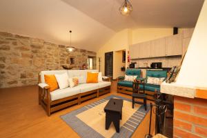 ein Wohnzimmer mit einem Sofa und einer Küche in der Unterkunft Casa do Parente in Sabroso