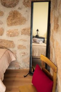 einen Spiegel in einem Zimmer mit einer Steinmauer in der Unterkunft Casa do Parente in Sabroso