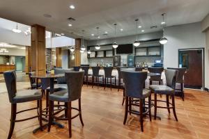 un restaurante con un bar con mesas y sillas en Drury Inn & Suites Phoenix Happy Valley, en Phoenix