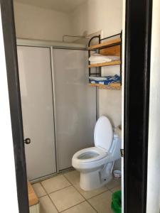 une salle de bain avec des toilettes blanches dans une chambre dans l'établissement Villas Coral Deluxe, à Manzanillo