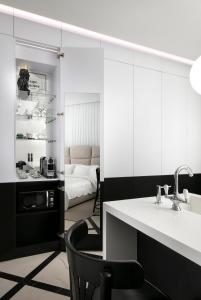 a bathroom with a sink and a chair and a bedroom at King George suites in Jerusalem