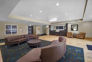 サムターにあるCandlewood Suites Sumter, an IHG Hotelの革製家具とリビングルームが備わるホテルロビー
