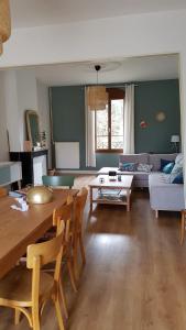 ein Wohnzimmer mit einem Sofa, einem Tisch und Stühlen in der Unterkunft Gîte de la Croisette in Sommeilles