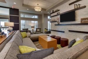 a living room with a couch and a tv at Drury Inn & Suites Cleveland Beachwood in Beachwood