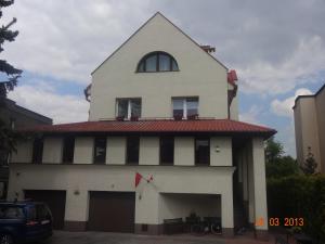 a white building with a red roof and a window at Centro Unita in Krakow