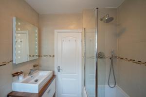 La salle de bains est pourvue d'un lavabo blanc et d'une douche. dans l'établissement Mayfair Central London, à Londres