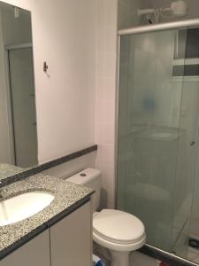 La salle de bains est pourvue de toilettes et d'une douche en verre. dans l'établissement Apartamento Rocha Cuiabá, à Cuiabá