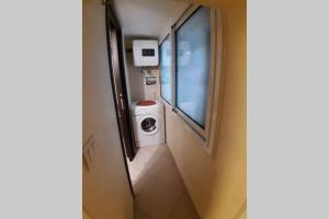 a small bathroom with a washing machine and a mirror at Olimpia House - Central Station in Bari
