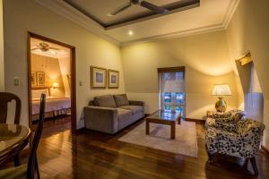 ein Wohnzimmer mit einem Sofa und einem Bett in der Unterkunft Hotel San Carlos in Guatemala