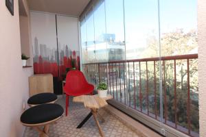 Habitación con silla roja y ventana grande. en Studio Mignon en Sarajevo