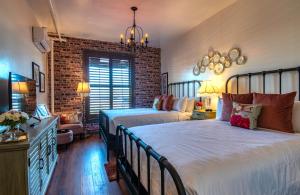 um quarto com 2 camas e uma parede de tijolos em The Clinkscale em Jerome