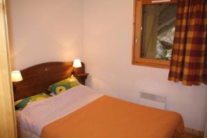 Un pat sau paturi într-o cameră la Le Cottage des Sybelles
