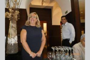 a woman standing in front of a table of wine glasses at A casinha do beco in Gouveia
