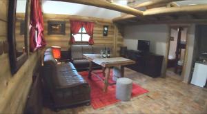 a living room with a table and a couch at Apartman Zelengora Dolina mira in Pale