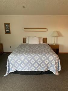 ein Schlafzimmer mit einem Bett mit einer blauen und weißen Decke in der Unterkunft Marina Motel in Seward