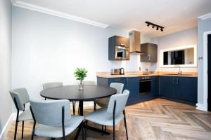 a kitchen with blue cabinets and a table and chairs at Staycity Aparthotels, Dublin, Christchurch in Dublin