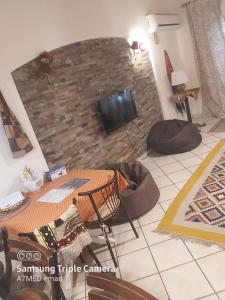 Luxury Chalet - La Hacienda في رأس سدر: غرفة معيشة مع طاولة وتلفزيون