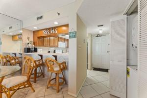 a kitchen and dining room with a table and chairs at Commodore 1002 in Panama City Beach