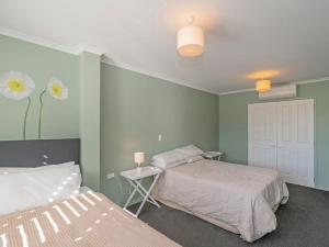 - une chambre avec 2 lits et une table avec un lit sidx sidx dans l'établissement Beach on Buffalo - Whitianga Holiday Home, à Whitianga