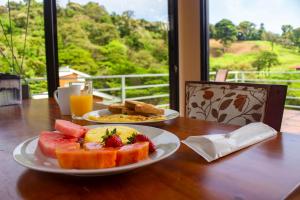 a table with two plates of food and fruit on it at Burbi Lake Lodge Monteverde in Monteverde Costa Rica