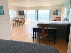 a bedroom with a desk and a kitchen with a table and chairs at Malibu Private Beach Apartments in Malibu
