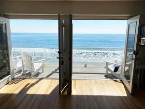 Cette chambre avec porte ouverte offre une vue sur l'océan. dans l'établissement Malibu Private Beach Apartments, à Malibu