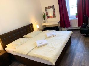 een slaapkamer met een bed met twee handdoeken erop bij Hotel Stará Pošta in Zdiby