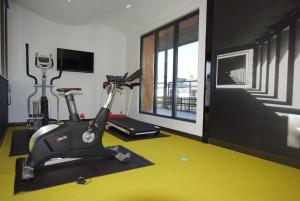 une salle de sport avec un tapis de course et un vélo dans l'établissement Le Privilège, à Châteaubourg