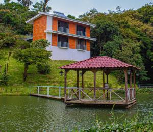 una casa con un cenador en medio de un lago en Burbi Lake Lodge Monteverde, en Monteverde