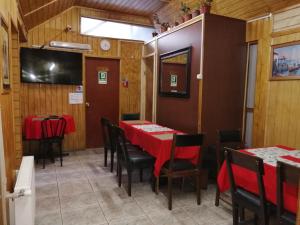 una sala da pranzo con tavoli e sedie rossi di Hostal Copiapó Puerto Montt a Puerto Montt