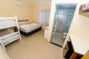 a small room with a bed and a shower at Pousada Morada dos ANJOS in Penha +142 photos
