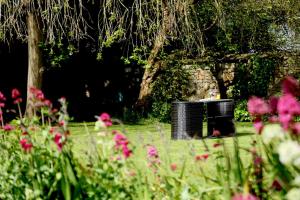 a garden with pink flowers and a trash can at Best Western Henbury Lodge Hotel in Bristol