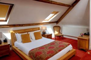 a bedroom with a bed and a chair at Best Western Henbury Lodge Hotel in Bristol