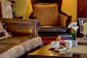 a living room with a leather chair and a table with a coffee table sidx sidx at Best Western Henbury Lodge Hotel in Bristol