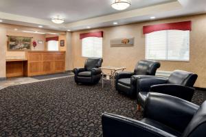 a waiting room with black chairs and a table at Travelodge by Wyndham Clinton Valley West Court in Clinton