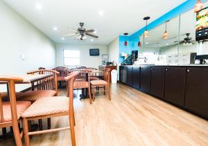 ein Restaurant mit Tischen und Stühlen und einer Theke in der Unterkunft Super 8 by Wyndham Searcy AR in Searcy