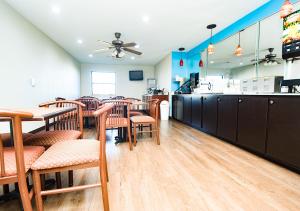 a restaurant with tables and chairs and a counter at Super 8 by Wyndham Searcy AR in Searcy