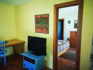 a living room with a television and a bedroom at The Sandcastle in Pohara