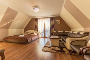 a attic bedroom with a bed and a couch at Willa Bustryk in Bustryk