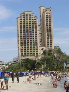 un grupo de personas en una playa con edificios altos en Edificio el Peñón del Rodadero Apto 1102 B en Santa Marta