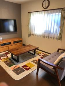 a living room with a coffee table and a tv at FunHome名古屋城 in Nagoya