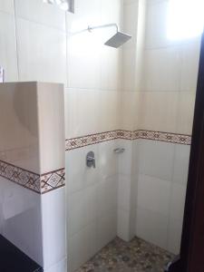 La salle de bains est pourvue d'une douche avec une porte en verre. dans l'établissement Sarwi homestay, à Ubud