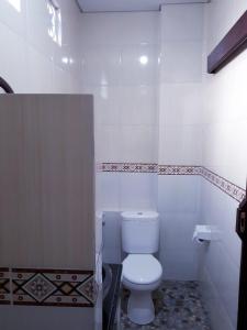 La salle de bains blanche est pourvue de toilettes. dans l'établissement Sarwi homestay, à Ubud