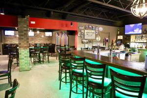 um bar num restaurante com um monte de bancos em Stanford Inn & Suites em Grande Prairie