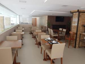 a dining room with tables and chairs and a unintention at Flat no Guest Manaíra Apart Hotel in João Pessoa