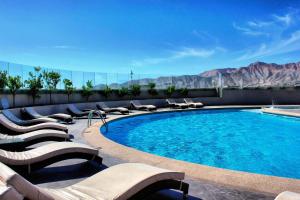 a pool with lounge chairs and a view of the mountains at Antay Casino Hotel in Copiapó